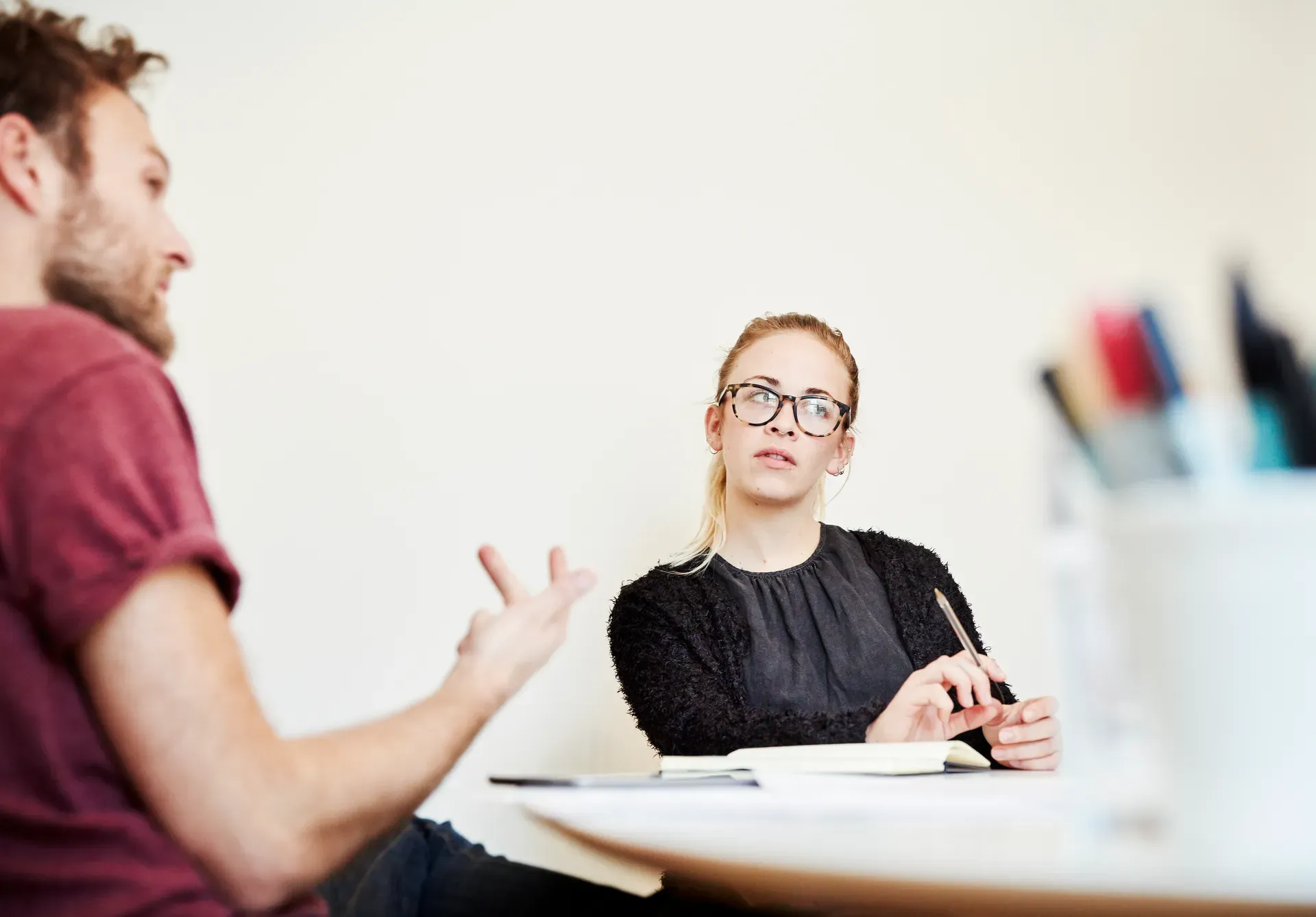 Ein Mann und eine Frau besprechen Unterlagen an einem Tisch
